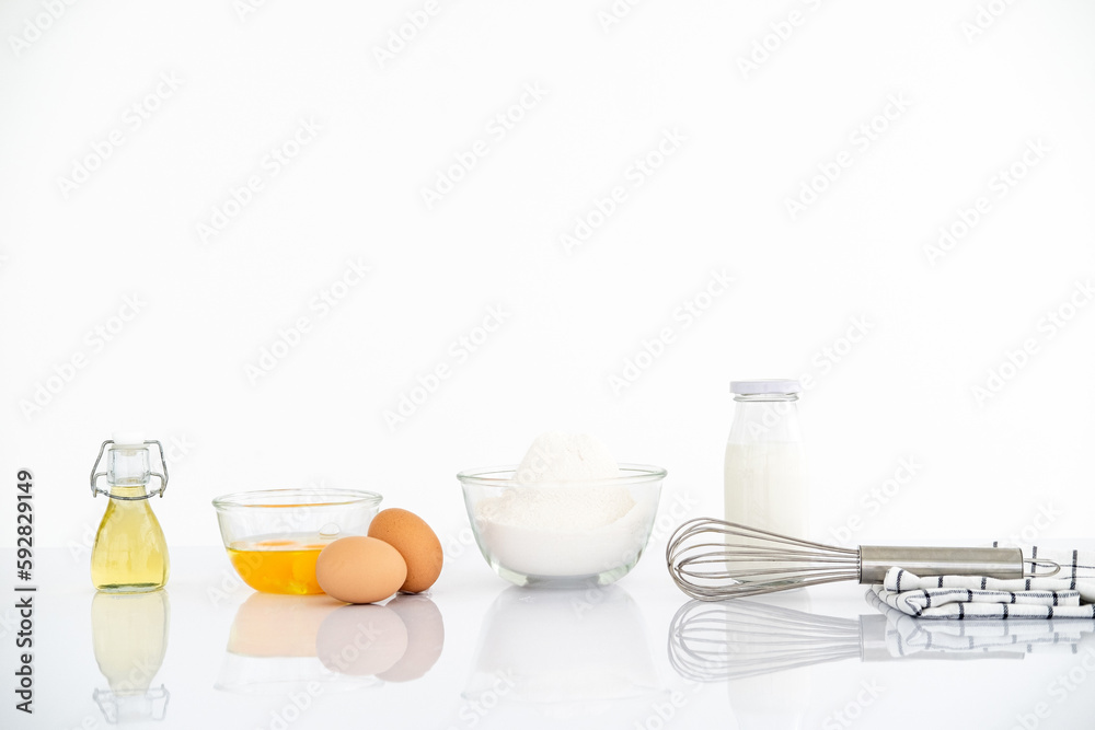Baking ingredients on white reflect table over defocused white kitchen wall background. Baking ingredients on white reflect table over defocused white kitchen wall background.