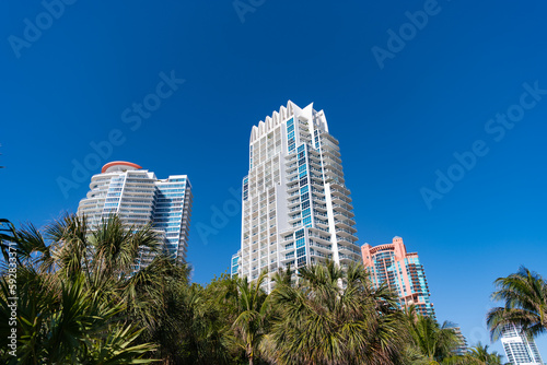 Modern towerblocks high-rise buildings architecture and palms on blue sky in South Beach, USA © be free