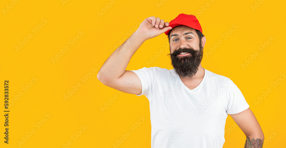 photo of bearded deliveryman with cap, advertisement. bearded deliveryman isolated on yellow.