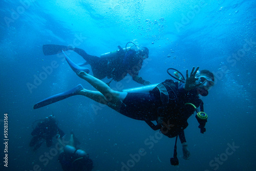 Woman scuba diving in deep blue sea banner on black background