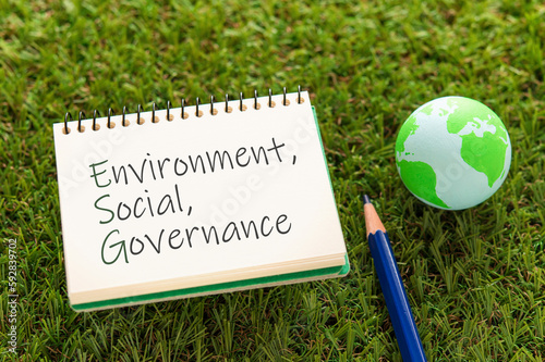 There is a notebook with the word Environment, Social, Governance and an earth ball. It is eye-catching image.