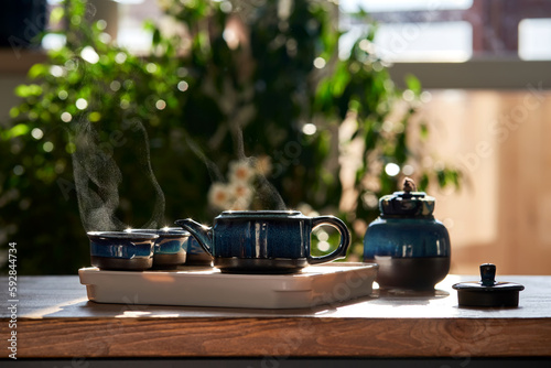 Tea set of deep blue color on a background of greenery.