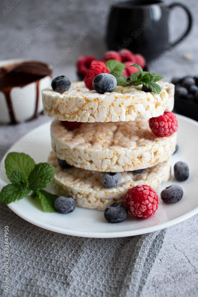 Rice cakes with berries and chocolate. Deliciously. A snack On a gray background Rice cakes with berries and chocolate. Deliciously. A snack On a gray background