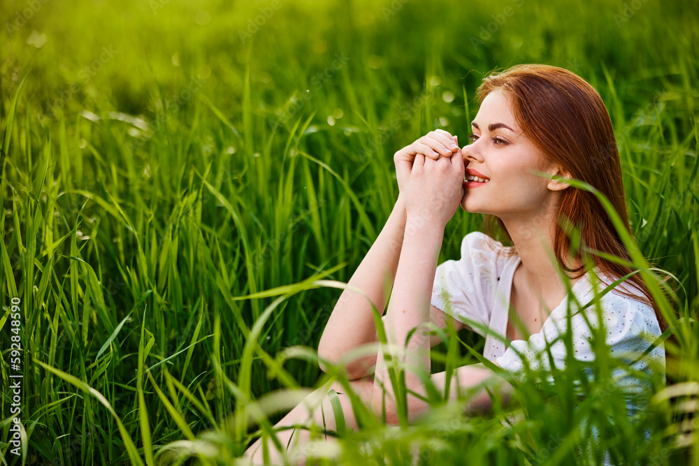 adorable woman sitting in nature resting in tall grass adorable woman sitting in nature resting in tall grass
