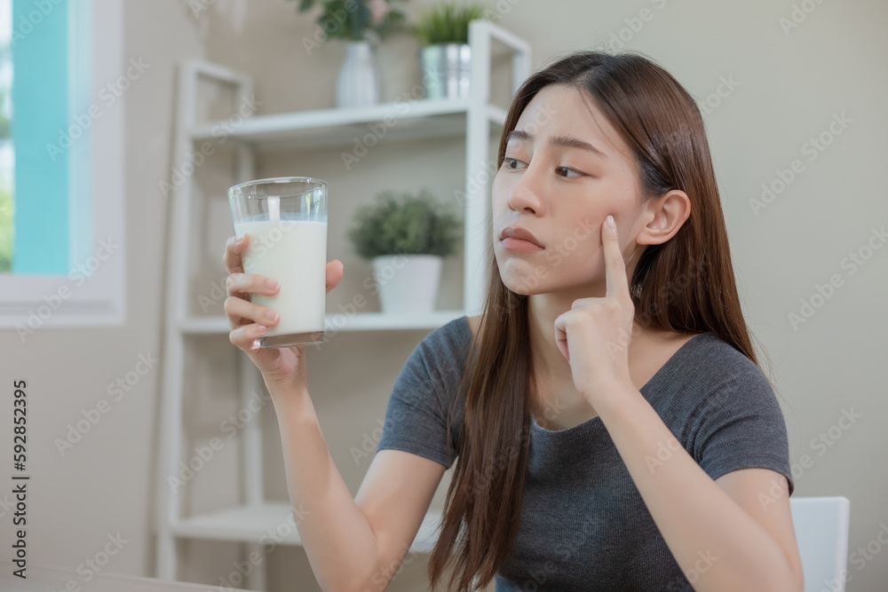 Asian female holding glass milk. resistance deny drinking milk, symptom