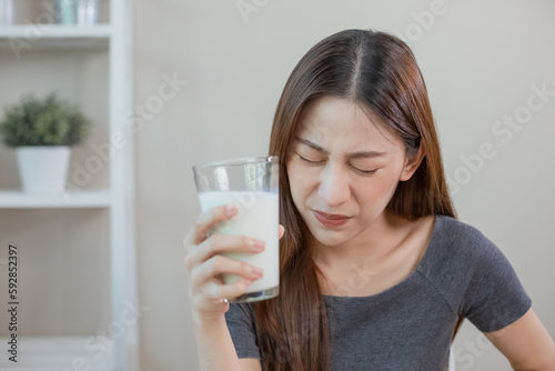 Asian female holding glass milk. resistance deny drinking milk  symptom lactose allergy  concept of health problem  women intolerance ingredient from calcium  stomach ache painful.