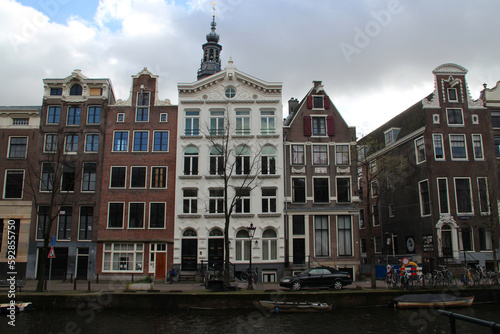 canal, river and old brick houses or flat buildings in amsterdam (the netherlands) 
