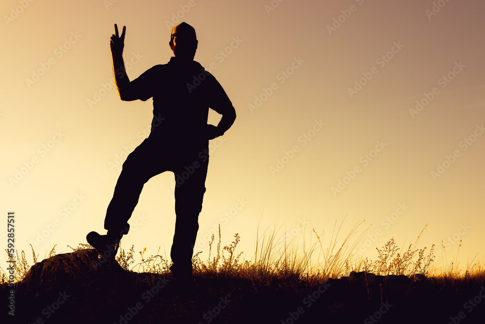 the silhouette of a man outside the room raises two fingers up as a sign of victory the silhouette of a man outside the room raises two fingers up as a sign of victory