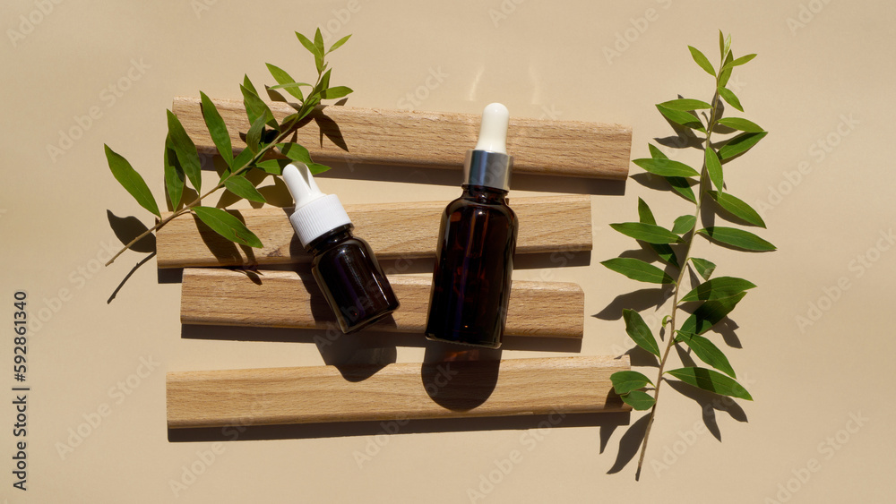 dark glass bottles for cosmetics with a pipette lie on wooden boards dark glass bottles for cosmetics with a pipette lie on wooden boards