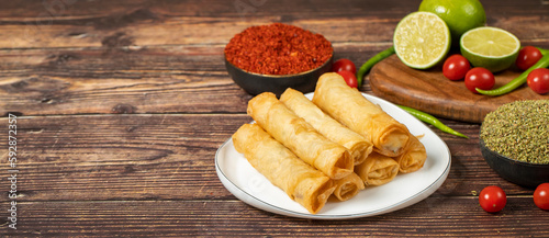 Cigarette pastry. Cheese pie on wood floor. Fried cheese rolls with phyllo. Local name sigara boregi. Empty space for text. copy space