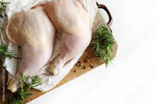 Due cosce di pollo crude fresche sul tagliere di legno. Coscia di pollo intera. Prodotti a base di carne cruda. Vista dall'alto. photo