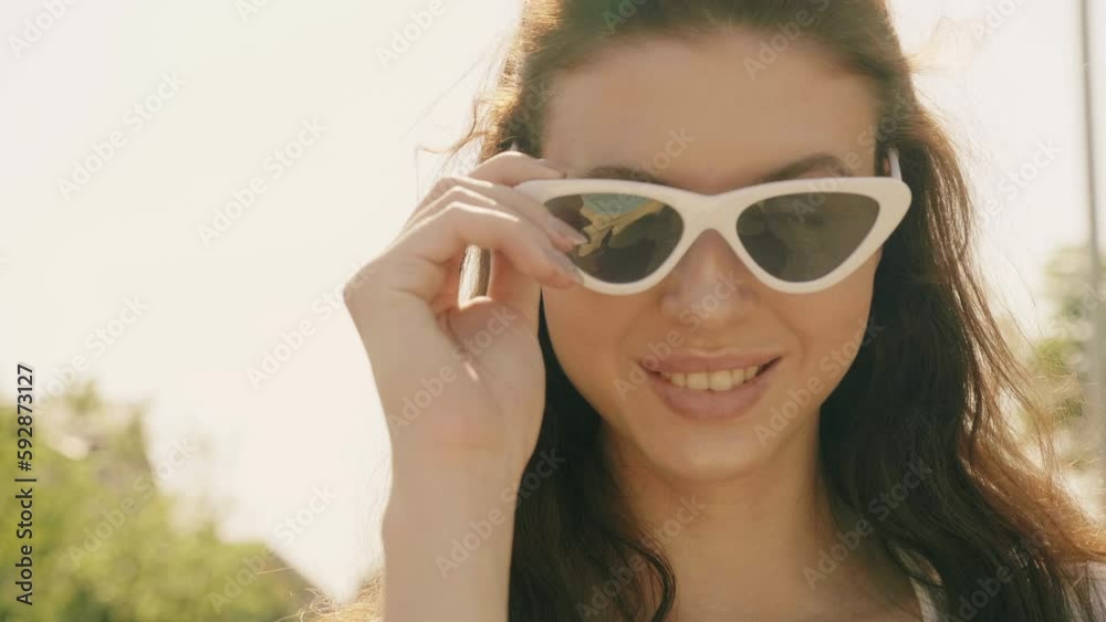Portrait of beautiful smiling model dressed in summer hipster jeans shorts clothes. Trendy girl posing in the street. Funny and positive woman having fun in sunglasses Portrait of beautiful smiling model dressed in summer hipster jeans shorts clothes. Trendy girl posing in the street. Funny and positive woman having fun in sunglasses