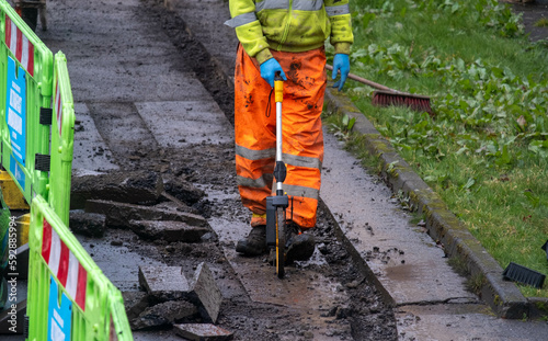 Construction worker wearing high-vis safety clothes using a surveyor's wheel