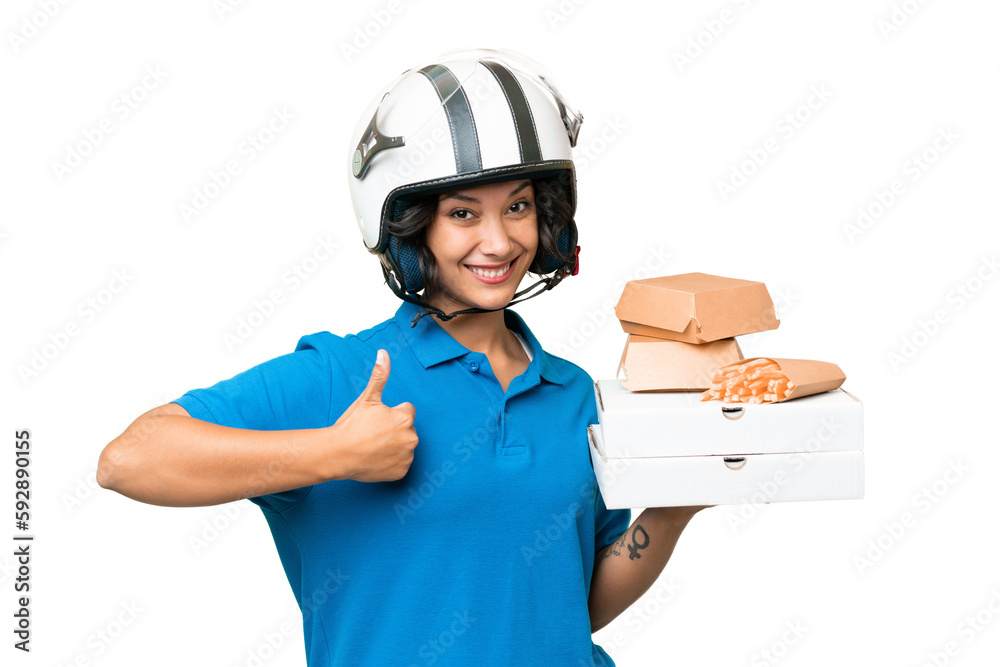 Young Argentinian deliver fast food over isolated background with thumbs up because something good has happened Young Argentinian deliver fast food over isolated background with thumbs up because something good has happened
