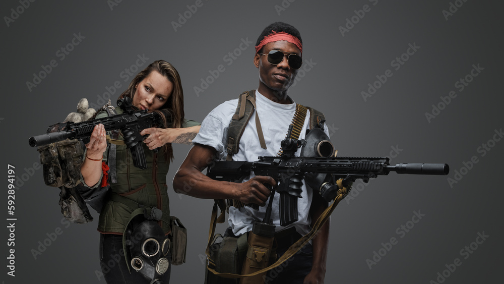 Studio shot of black macho man and woman survivors in post apocalyptic setting. Studio shot of black macho man and woman survivors in post apocalyptic setting.
