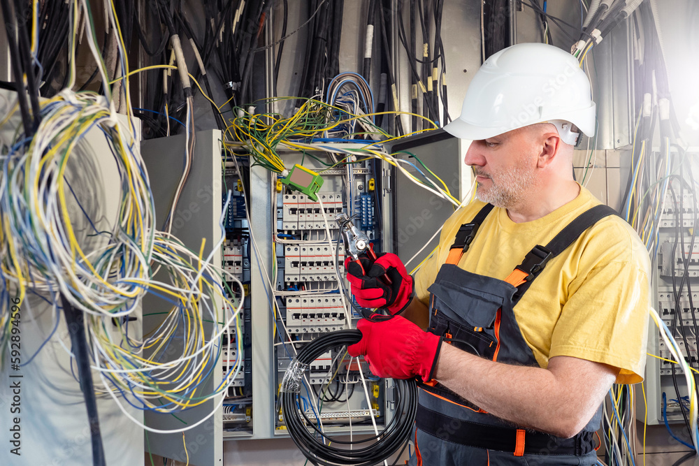 Electrician at work. Man among tangled wires. Unstructured electrical networks. Electrician is