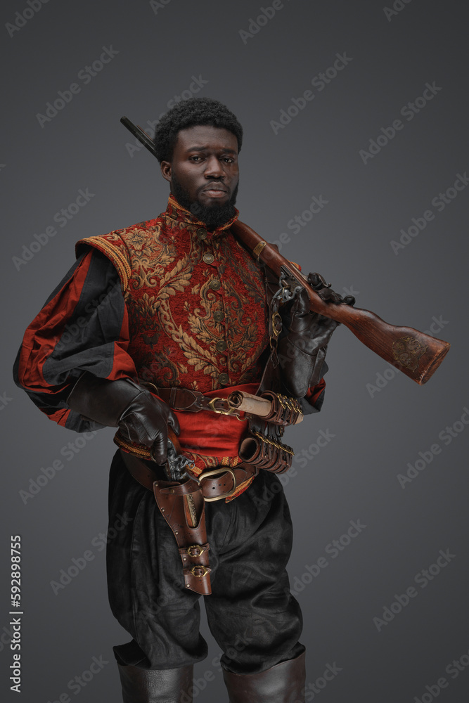 Shot of curly haired soldier dressed in stylish military suit against grey background. Shot of curly haired soldier dressed in stylish military suit against grey background.