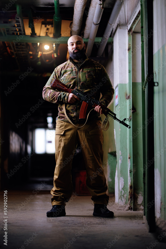 Fototapeta premium Portrait of the armed bearded man looking with a serious face straight at the camera