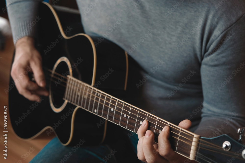 Playing the guitar. Strumming acoustic guitar. Musician plays music