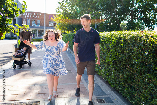 Happy girl with down syndrome talking to provider as they walk around the streets