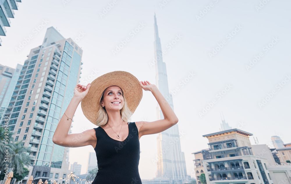 Young travelling woman in hat enjoying the view of Dubai downtown.