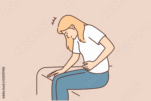 Woman suffering from stomach pain sitting on bed needs medicine after food poisoning