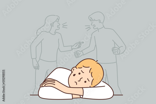 Sad boy sits near conflict of parents not paying attention to son with psychological troubles