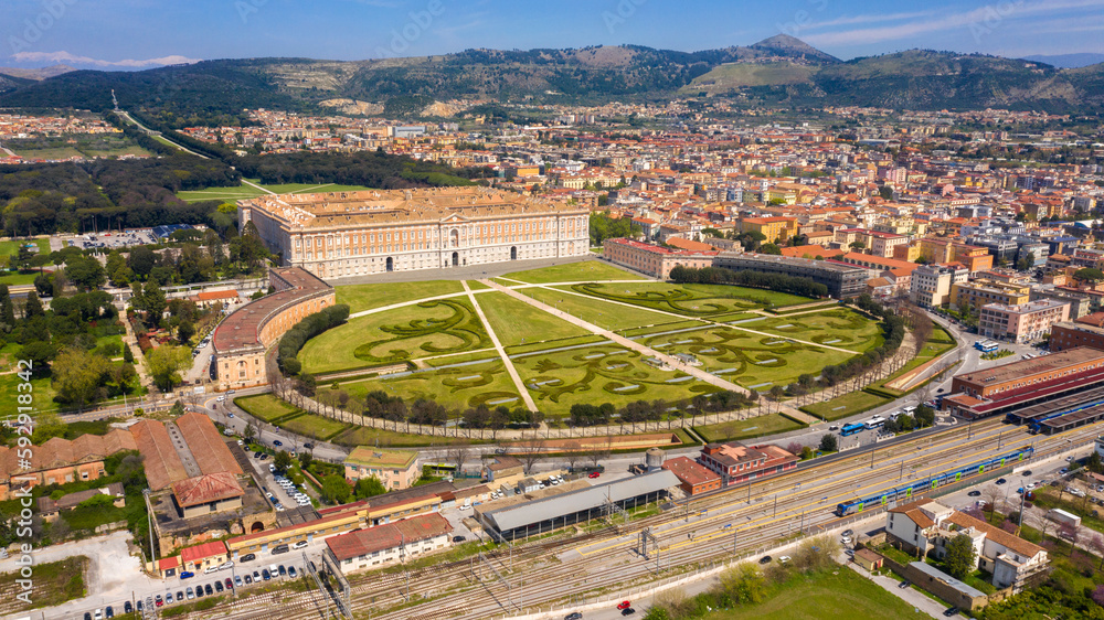 Aerial view of the Royal Palace of Caserta also known as Reggia di Caserta. It is a former royal residence with large gardens in Caserta, near Naples, Italy. The historic center of the city is nearby. Aerial view of the Royal Palace of Caserta also known as Reggia di Caserta. It is a former royal residence with large gardens in Caserta, near Naples, Italy. The historic center of the city is nearby.