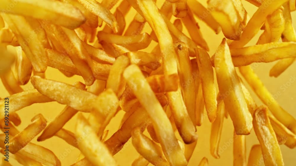 Super slow motion of flying French fries on yellow background. Filmed on high speed cinema camera, 1000 fps. Camera placed on high speed cine bot, tracking the target. Super slow motion of flying French fries on yellow background. Filmed on high speed cinema camera, 1000 fps. Camera placed on high speed cine bot, tracking the target.