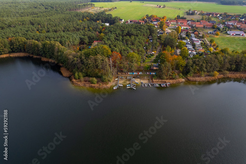 Aerial shot of beautiful lake surrounded by forest in a calm autumn day. Germany.