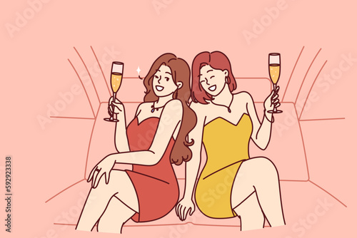 Celebrity women sit in luxury car with glasses filled with sparkling wine during pre-wedding bachelorette party. Celebrity girls in evening dresses riding in limousine enjoy premium atmosphere 