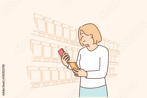 Woman looking for sweet chocolate on grocery store shelves choosing low calorie breakfast dessert