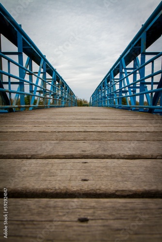 Vertical shot of a little bridge with blue fence during the day © Stéphan Rocoplan/Wirestock Creators