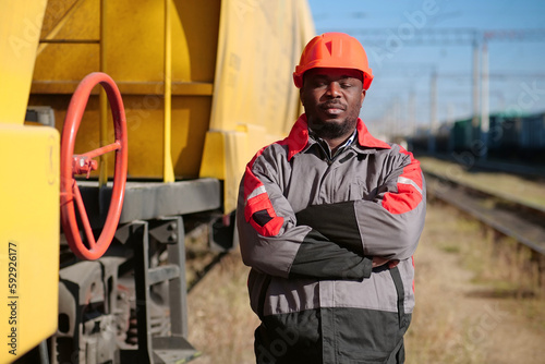 Railroad man in uniform and red hard hat look at the camera photo