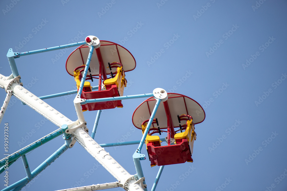 Ferris wheel, booths against the blue sky. Ferris wheel, booths against the blue sky.