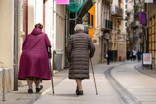 Old ladies walking through the old town with the help of a cane © Néstor MN