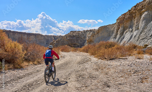 nice, active senior woman with her electric mountain bike on a trail tour in the dessert of Tabernas near Almeria, Andlusia, Spain
