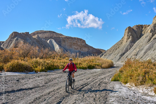 nice, active senior woman with her electric mountain bike on a trail tour in the dessert of Tabernas near Almeria, Andlusia, Spain