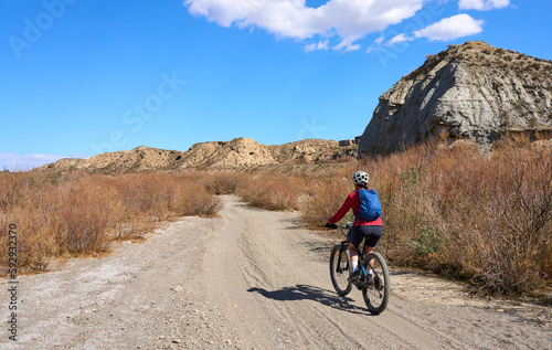 nice, active senior woman with her electric mountain bike on a trail tour in the dessert of Tabernas near Almeria, Andlusia, Spain