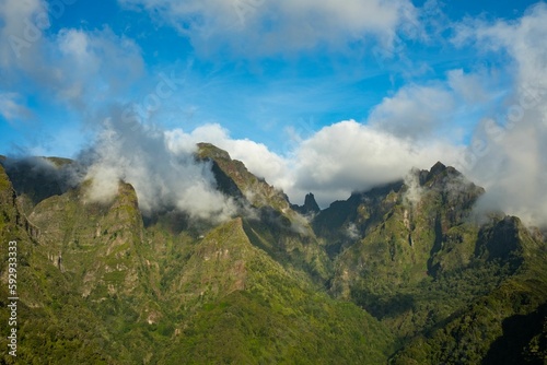 Aerial view of mountains with a cloudy blue sky in the background in Madeira Island, Portugal