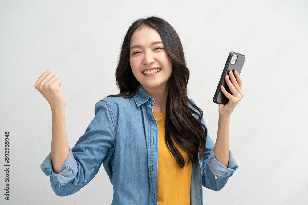 Happy Asian woman holding a smartphone and winning the prize. Happy Asian woman holding a smartphone and winning the prize.
