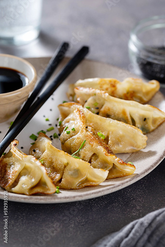 Fried dumplings gyoza with soy sauce, and chopsticks.
