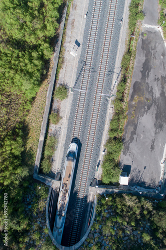 zenithal aerial view of a high-speed train tunneling out of a tunnel photo