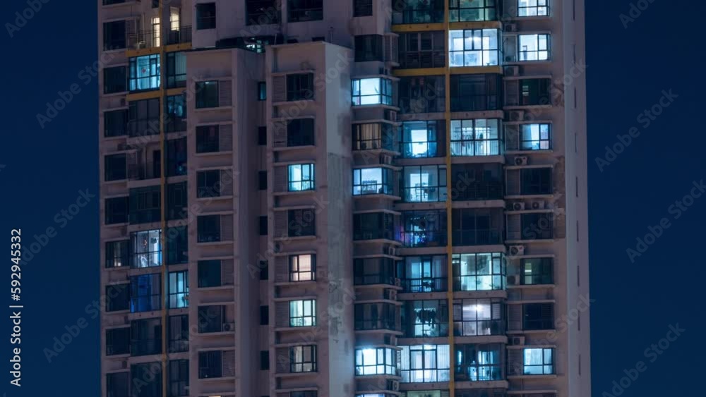 Nighttime view of a high buildings with light going on and off in the