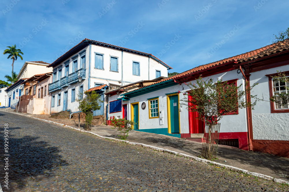 Sabará. Beautiful colorful old mansions in the historic city of Sabará. Brazil. Blue sky. Stone-paved street.