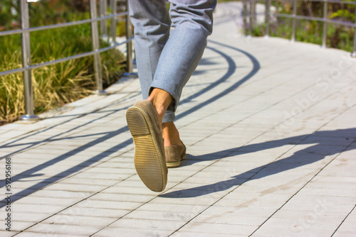 Φωτογραφία Businessman feet Man in gray pants walking on city street Business lifestyle