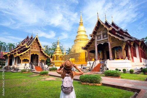 Φωτογραφία Asian traveller walking on street infront of wat phra singh temple