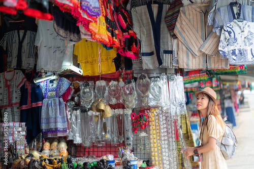 Asian traveller woman shoping traditioanl goods in souvenir shop in walking street in Chiang mai