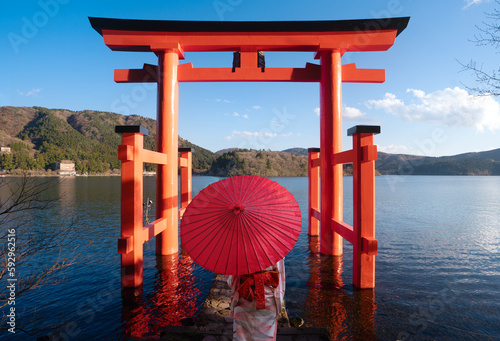 Tableau sur toile Asian couple in kimono wedding dress standing togather with red umbrella and red