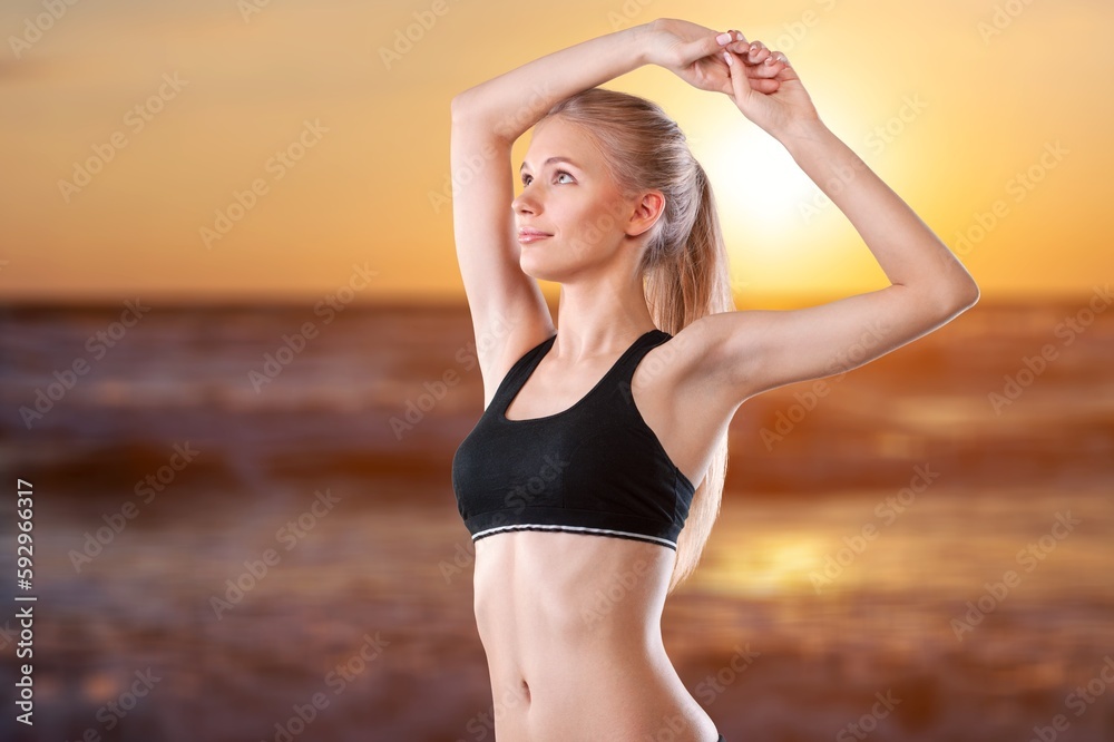 Young happy woman in yoga pose and meditation on beach.